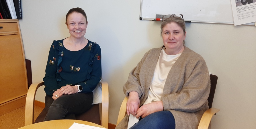 Maria Westin och Jenny Örnberg sitter ner i varsin stol med ett bord framför sig.