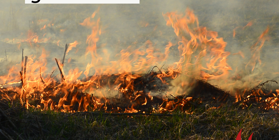 Ett foto på brinnande gräs med eldslågor och rök. Text på fotot: Risk för gräsbrand
